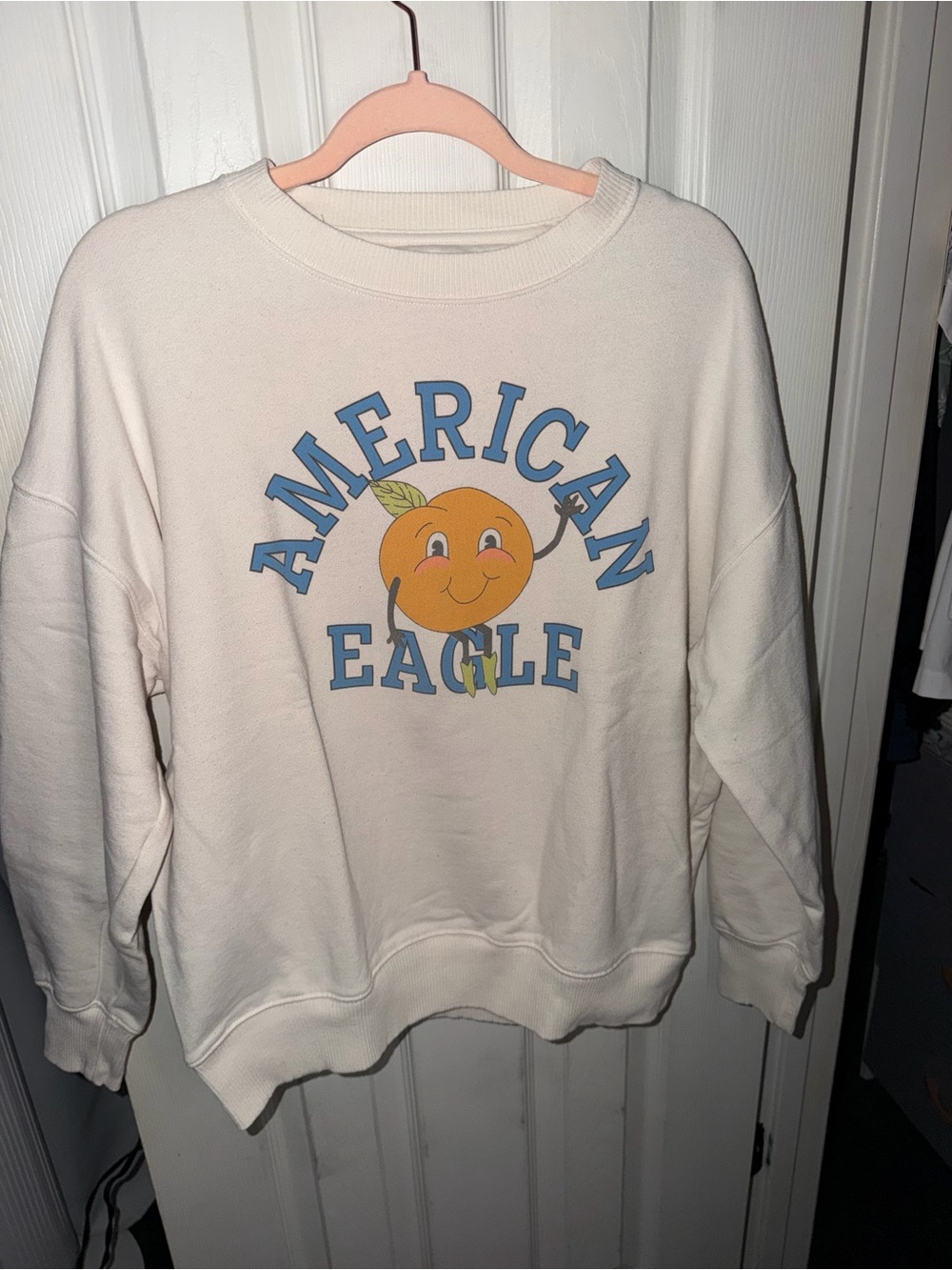 American Eagle Outfitters Cream Crewneck with Orange Graphic and Blue Lettering